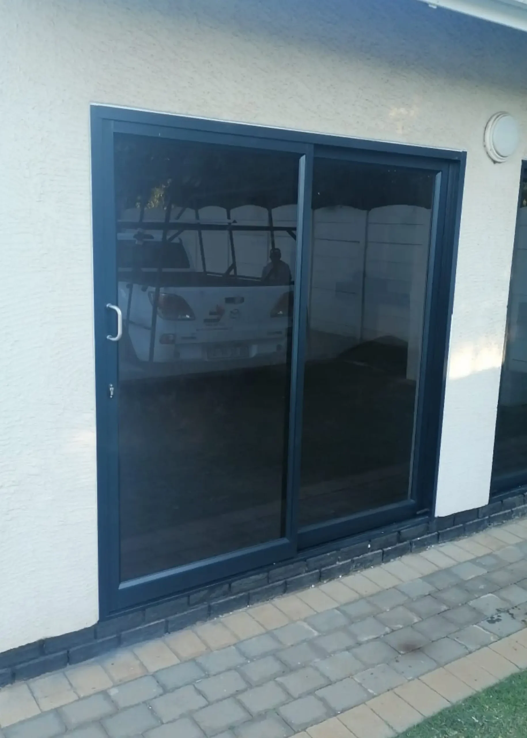 Aluminium entrance door with dark framing and glazed side panels